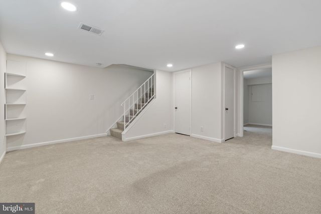 an empty room with stairs and white walls