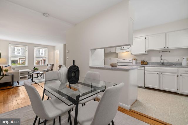 a kitchen with a dining table chairs and white appliances
