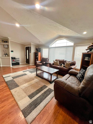 1407 North 1250th Street West Helper, UT 84526 - Photo 5 of 27 Living area with a textured ceiling, light wood-type flooring, and crown molding