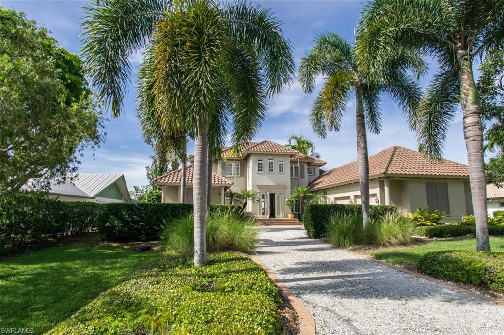 524 Turtle Hatch Road Naples, FL 34103 - Photo 1 of 24 a front view of a house with a garden