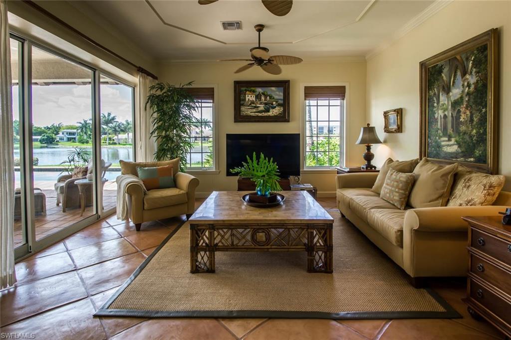 524 Turtle Hatch Road Naples, FL 34103 - Photo 15 of 24 a living room with furniture a chandelier and a fireplace