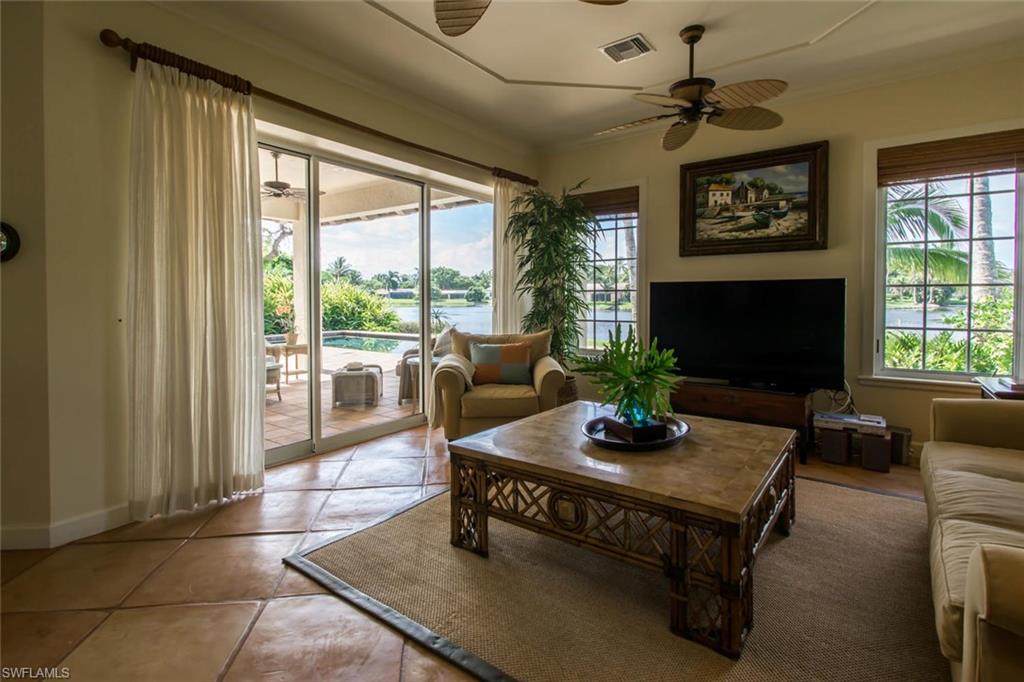524 Turtle Hatch Road Naples, FL 34103 - Photo 16 of 24 a living room with furniture a large window and a fireplace