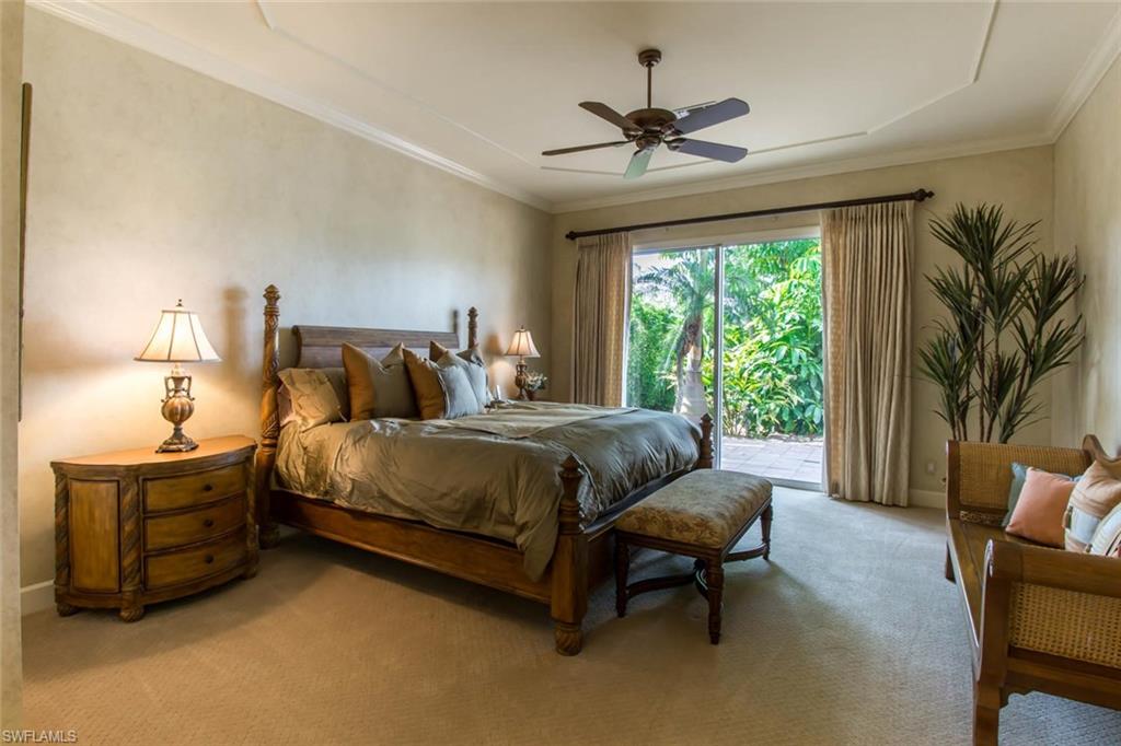 524 Turtle Hatch Road Naples, FL 34103 - Photo 17 of 24 a bedroom with a bed couches chair and a large window
