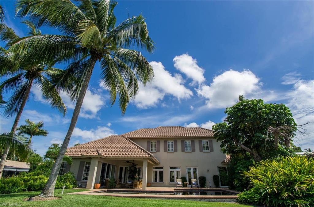 524 Turtle Hatch Road Naples, FL 34103 - Photo 2 of 24 a view of a white house with a big yard and palm trees