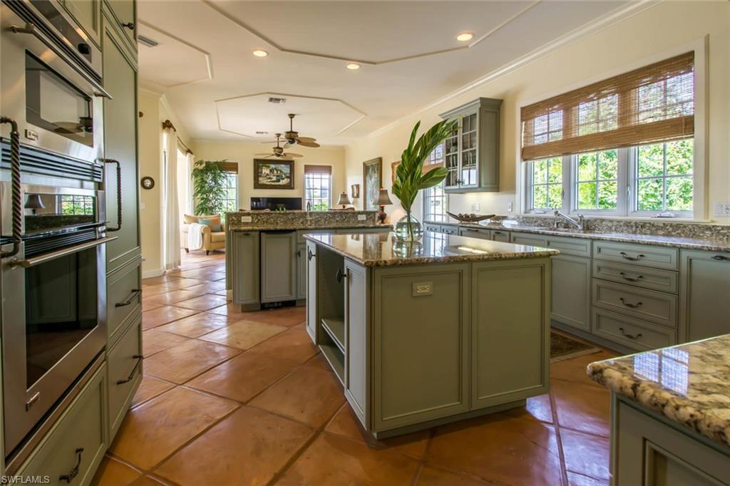 524 Turtle Hatch Road Naples, FL 34103 - Photo 7 of 24 a kitchen with stainless steel appliances granite countertop a sink and stove top oven