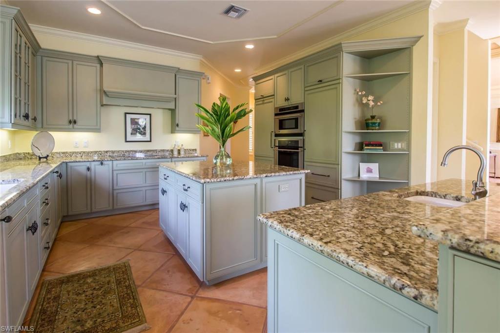 524 Turtle Hatch Road Naples, FL 34103 - Photo 9 of 24 a kitchen with kitchen island granite countertop a sink stove and cabinets