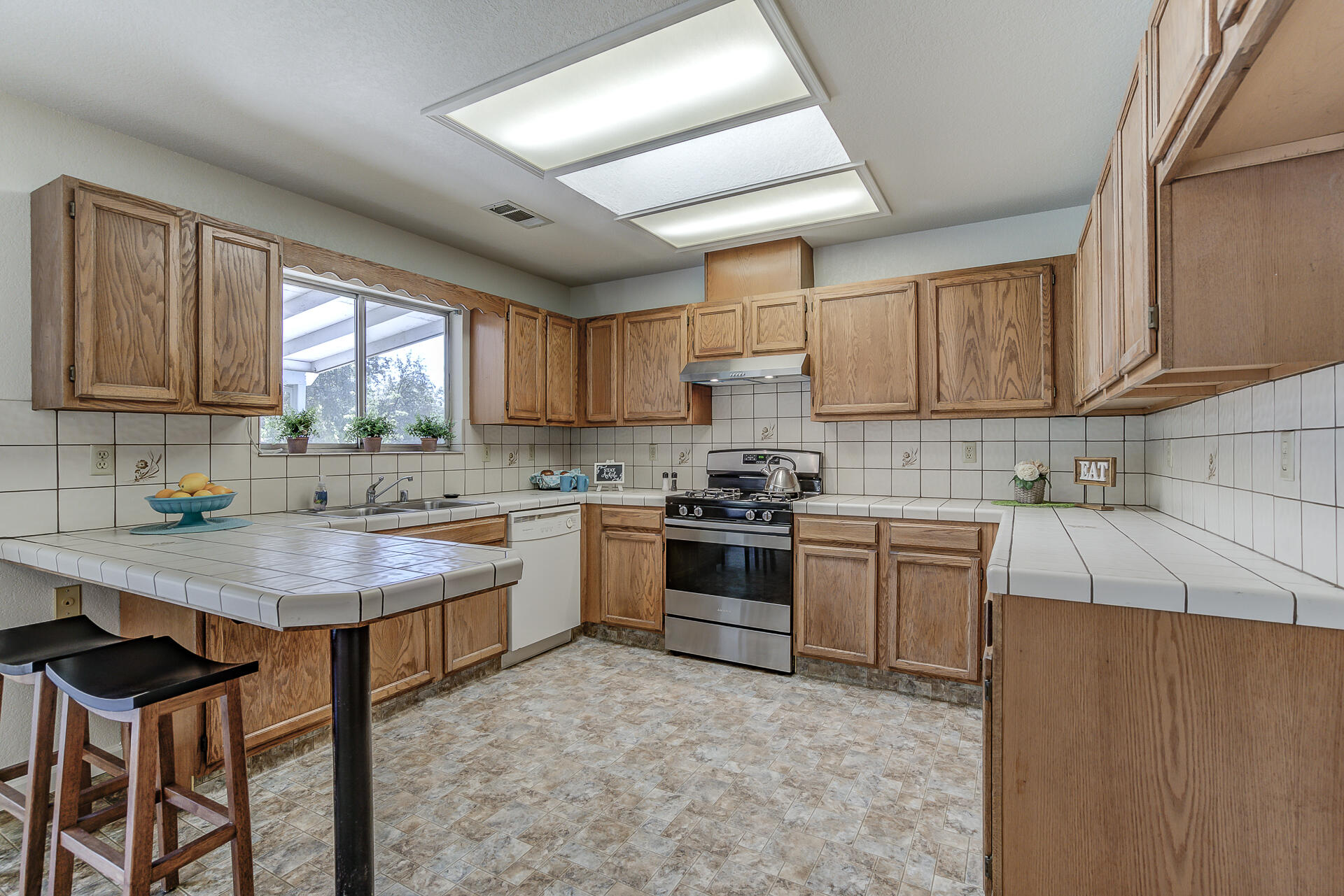 649 Lowe Street Redding, CA 96001 - Photo 5 of 35 a kitchen with a stove a sink a window and cabinets