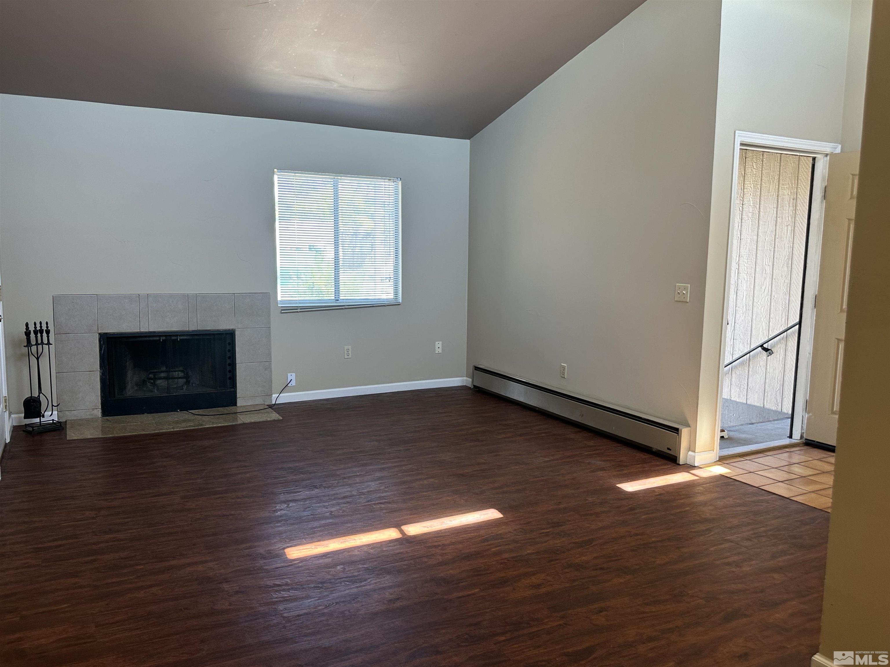 2101 Highview Court, Unit 18 Reno, NV 89512 - Photo 8 of 12 an empty room with wooden floor fireplace and windows