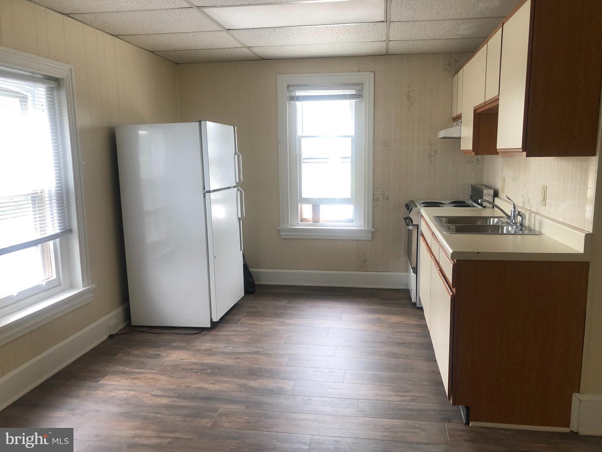70 North Main Street, Unit 3 Spring City, PA 19475 - Photo 4 of 11 a kitchen with granite countertop a refrigerator a sink a stove a microwave a counter top and cabinets