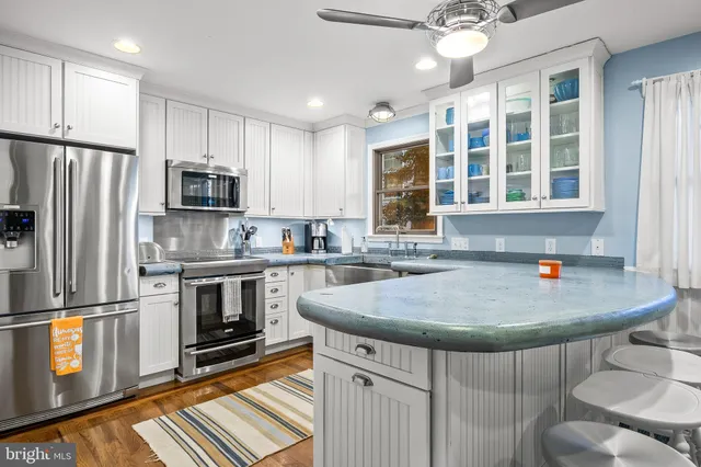 a kitchen with granite countertop white cabinets and a sink