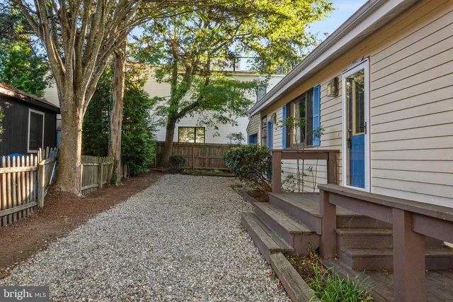 a view of a house with a yard and wooden fence
