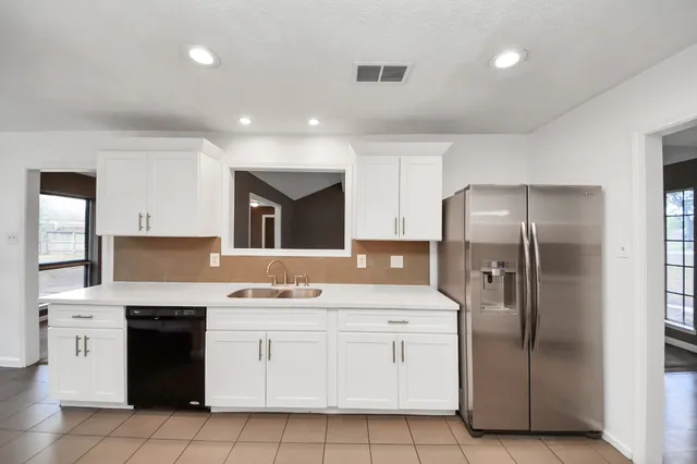 a large kitchen with stainless steel appliances granite countertop a stove a sink and a refrigerator