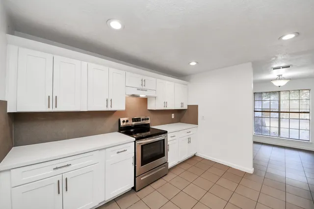 a kitchen with granite countertop a sink stainless steel appliances and cabinets