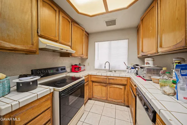 a kitchen with stainless steel appliances granite countertop a sink a stove and cabinets