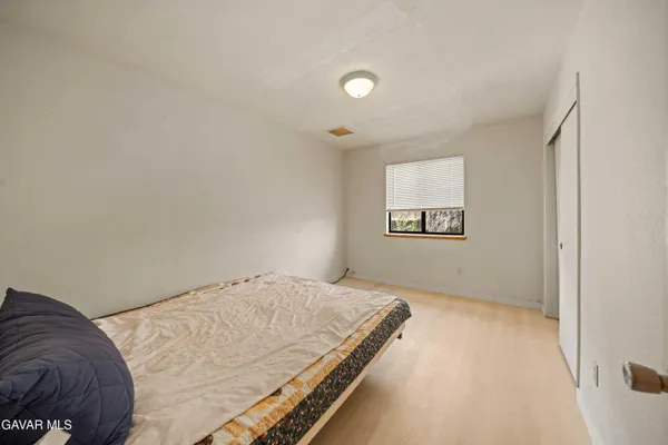 a view of a bedroom with a bed and a window