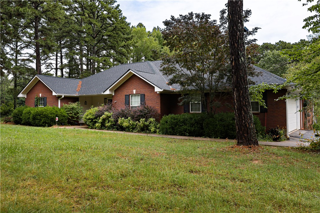 164 Park Road Russellville, AR 72802 - Photo 29 of 35 Brick exterior residence featuring a dark shingle roof, white trim, and a prominent front lawn
