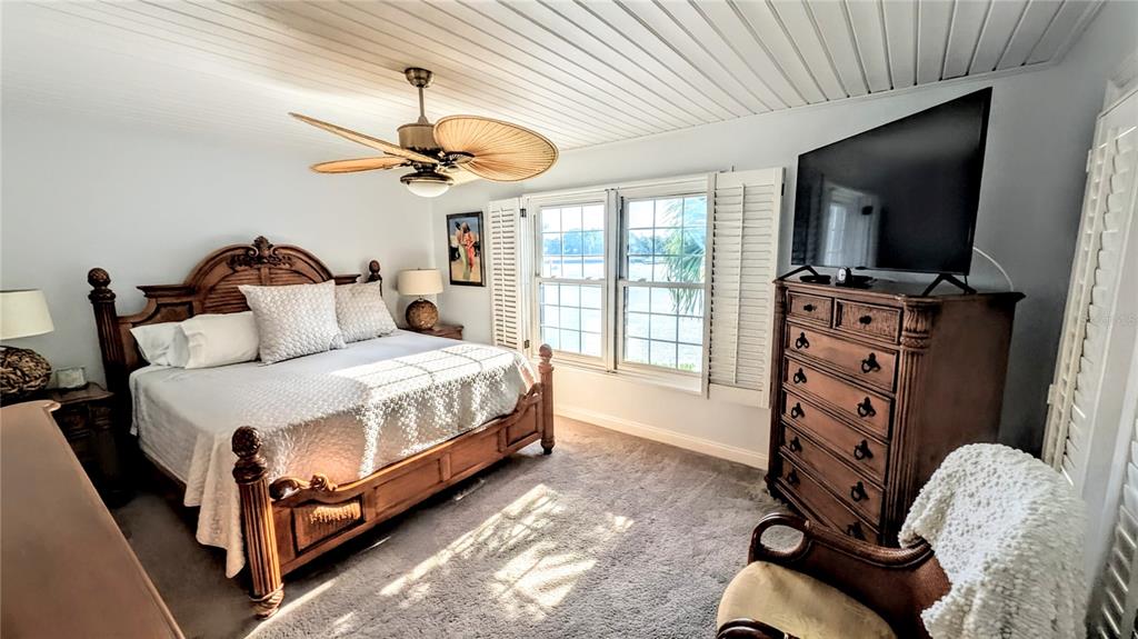 1546 Stickney Point Road, Unit 501 Sarasota, FL 34231 - Photo 15 of 34 a bedroom with a bed and a flat tv screen on a dresser