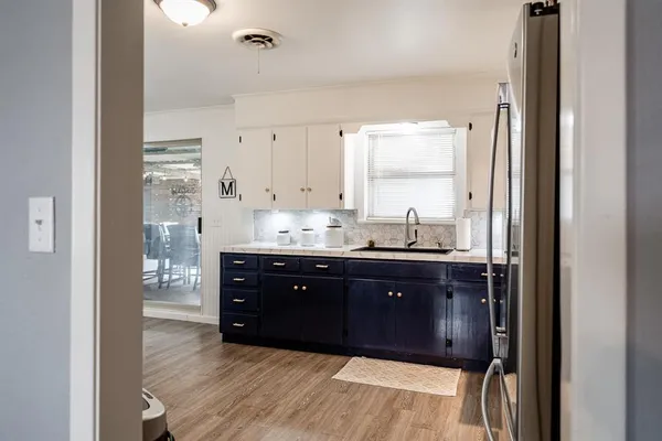 a room with stainless steel appliances granite countertop a refrigerator and a sink
