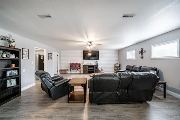 a living room with furniture a ceiling fan and a window