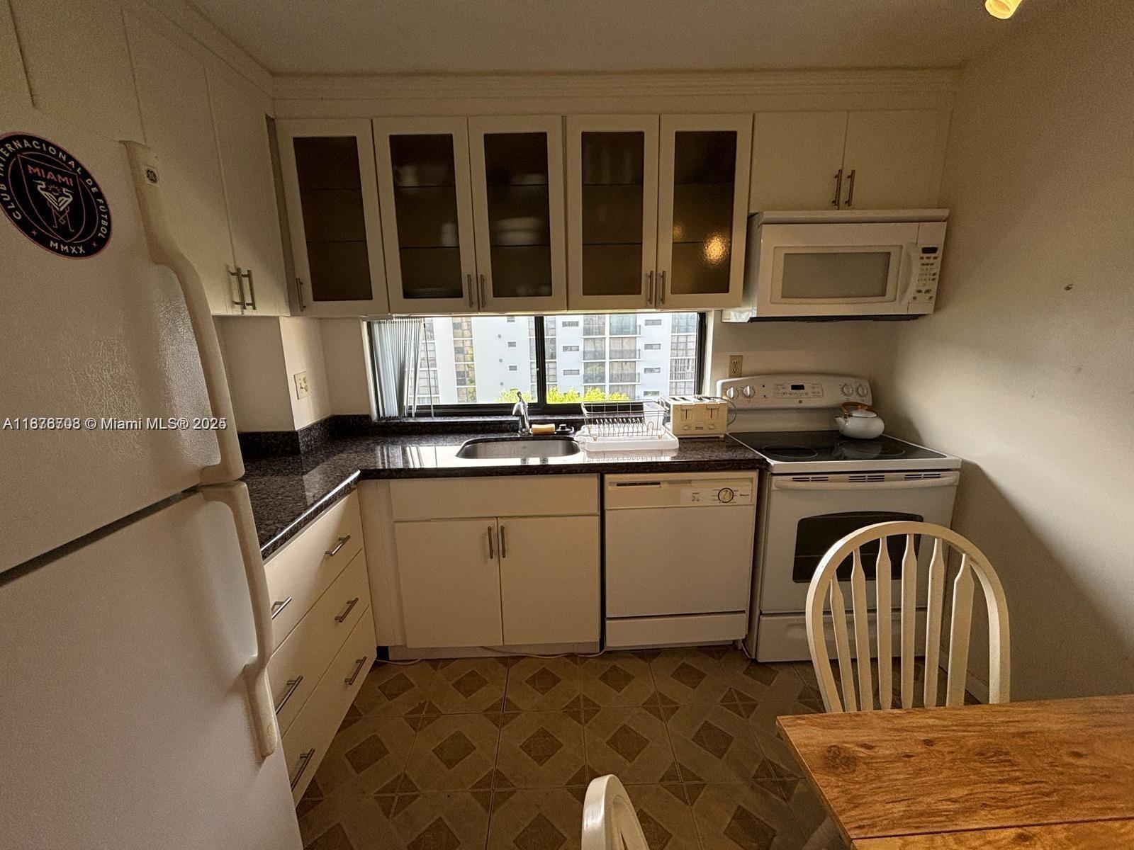 17011 North Bay Road, Unit 805 Sunny Isles Beach, FL 33160 - Photo 10 of 25 a kitchen with a refrigerator and a sink