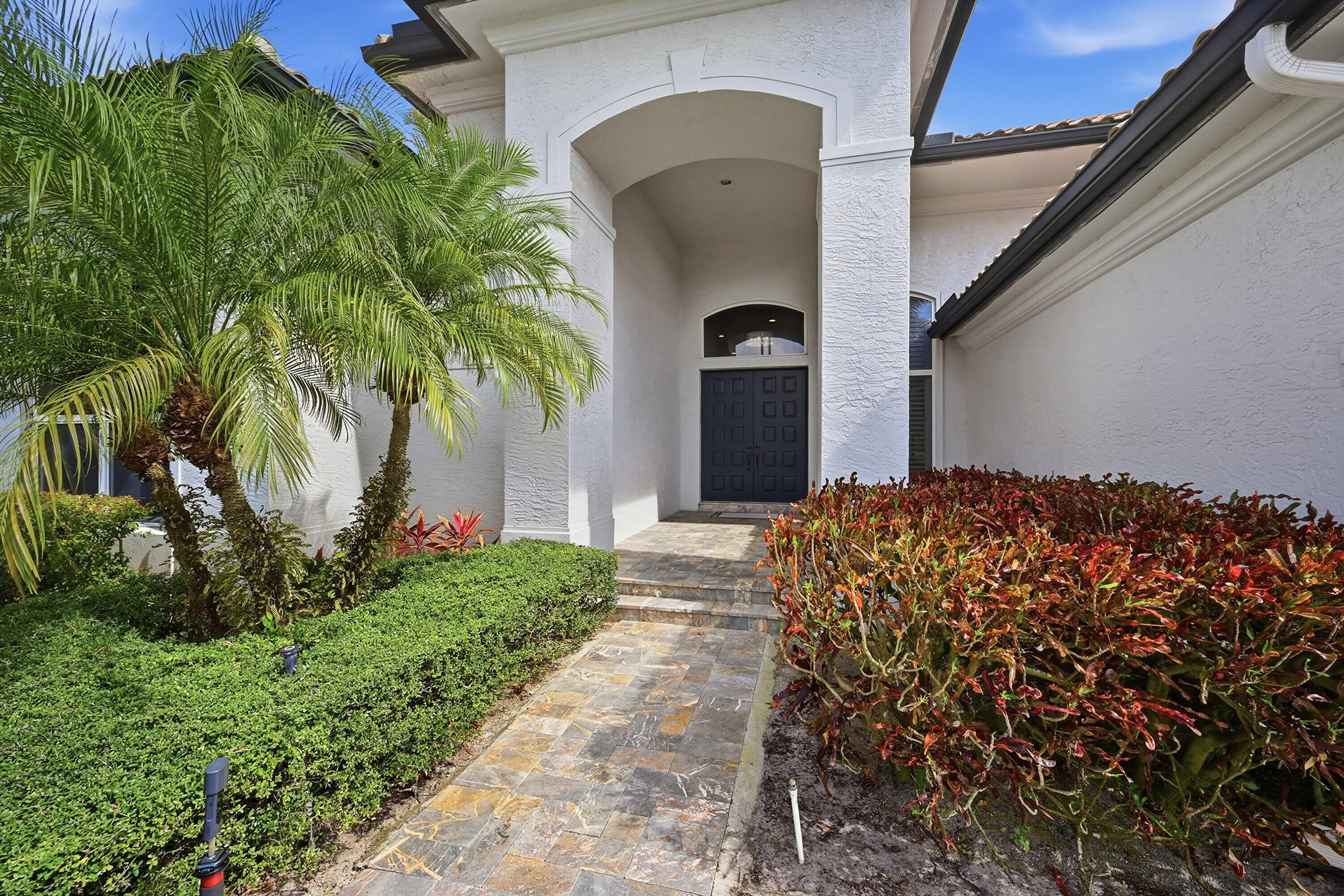 5006 Northwest 24th Circle Boca Raton, FL 33431 - Photo 2 of 52 a front view of a house with a yard