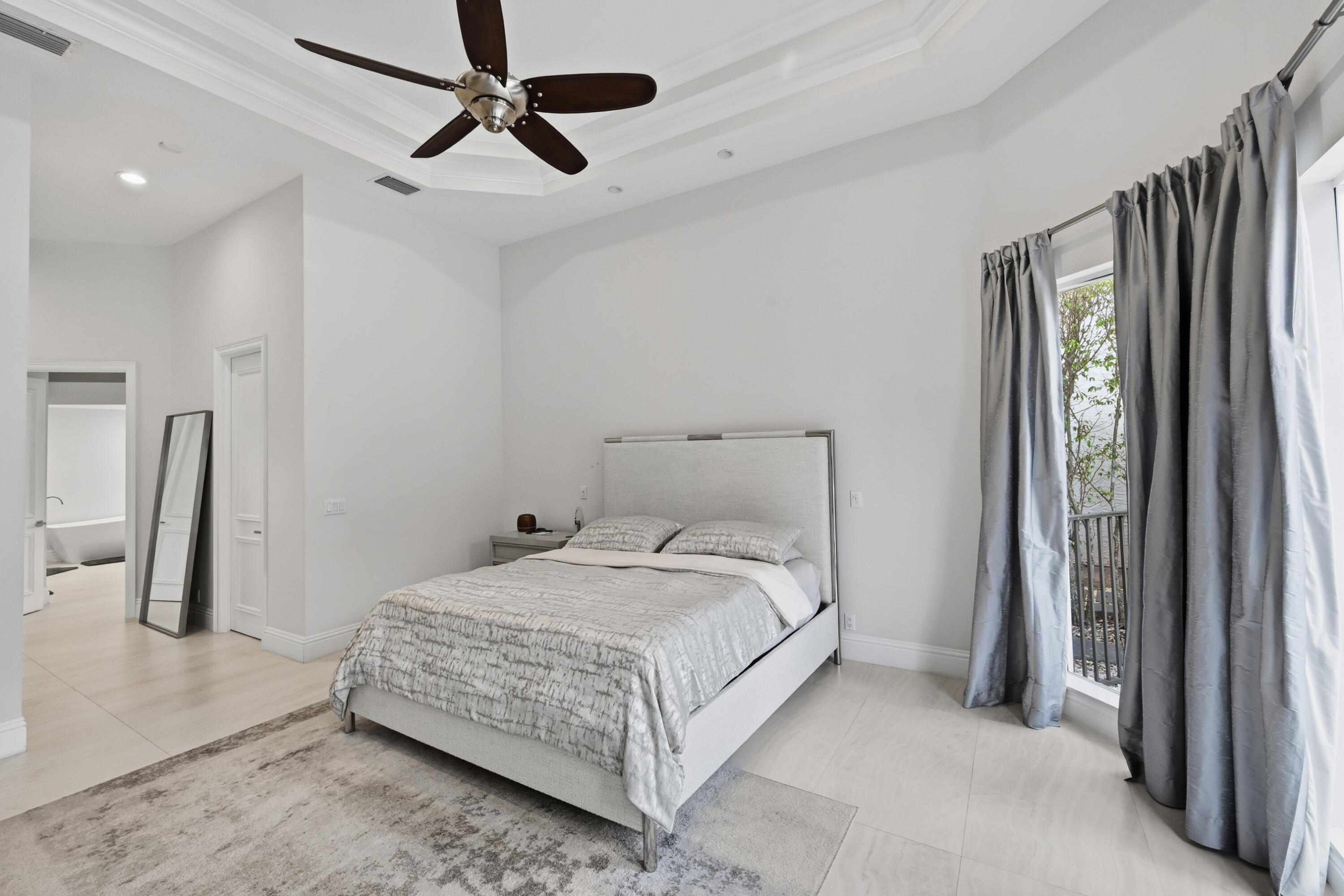 5006 Northwest 24th Circle Boca Raton, FL 33431 - Photo 22 of 52 a bedroom with a bed and a chandelier