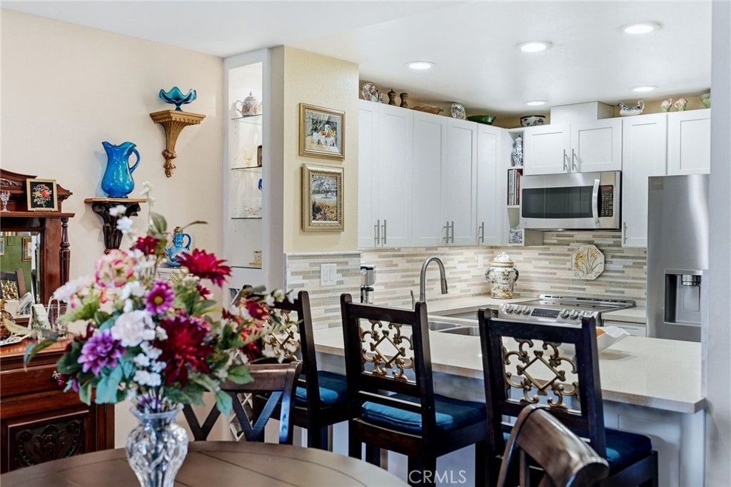 7890 East Spring Street, Unit 2L Long Beach, CA 90815 - Photo 13 of 47 a view of a dining room with furniture and a potted plant