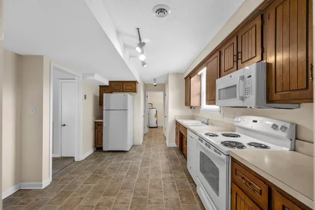 a kitchen with stainless steel appliances granite countertop a refrigerator a stove and a sink with dishwasher