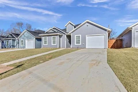 a view of a house with a yard and large trees
