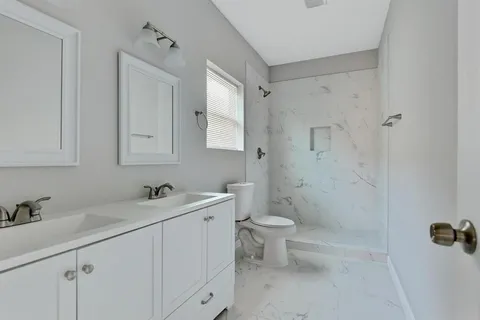 a bathroom with a sink toilet and shower