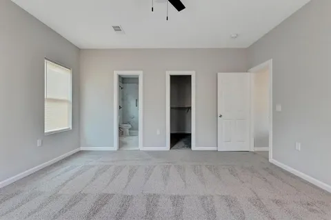 a view of an empty room with window and closet area