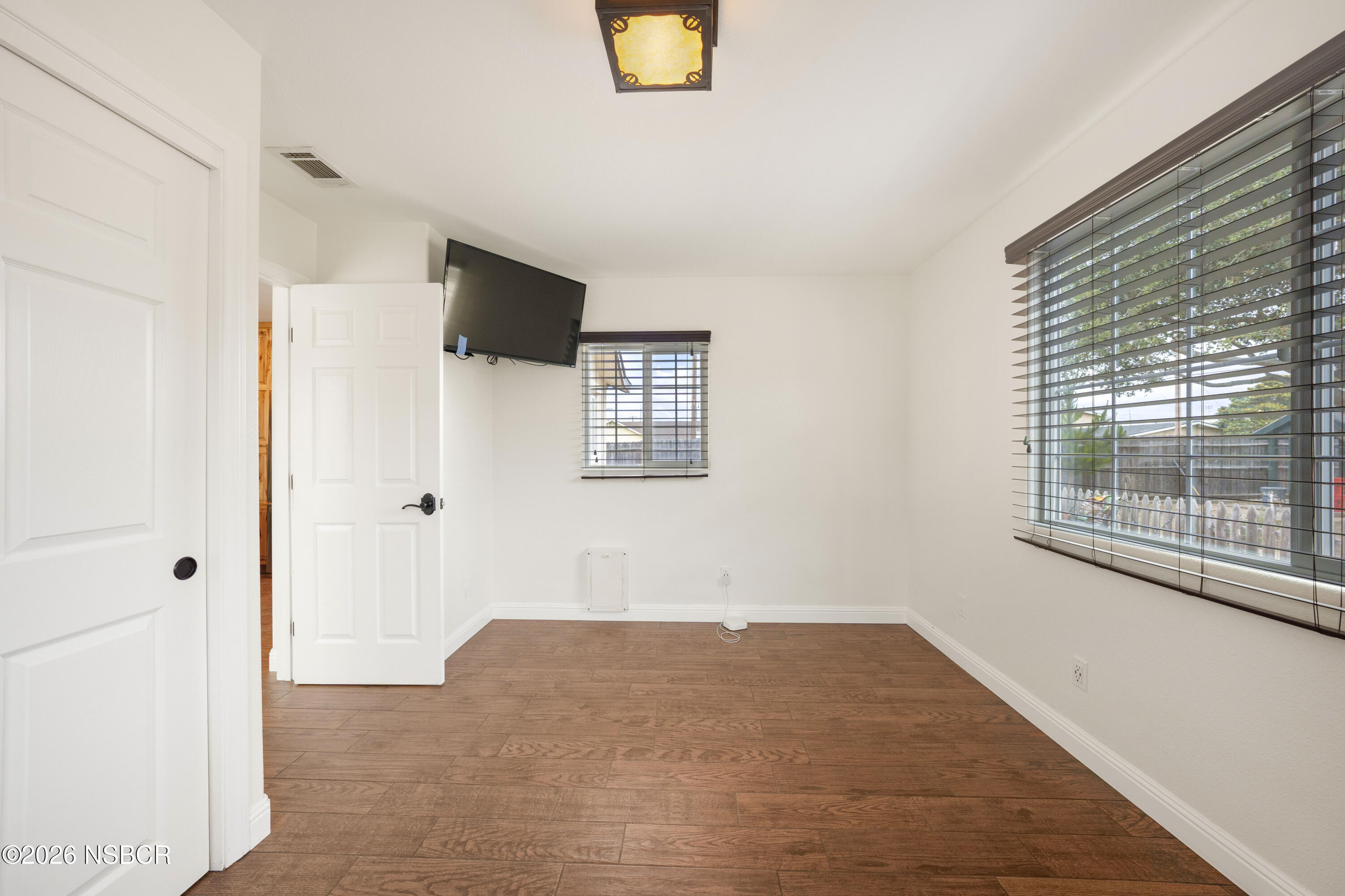 138 North E Street Lompoc, CA 93436 - Photo 17 of 35 a view of empty room with wooden floor and windows