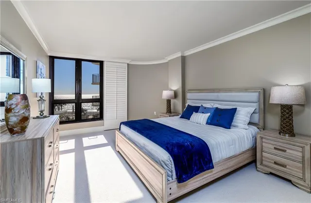 a bedroom with a bed and a large window