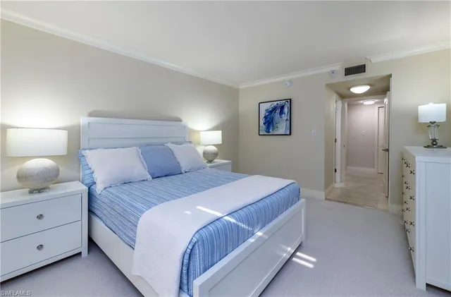 a bedroom with a bed and a lamp on dresser