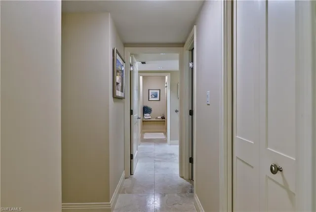 a view of a hallway with wooden floor and a bathroom