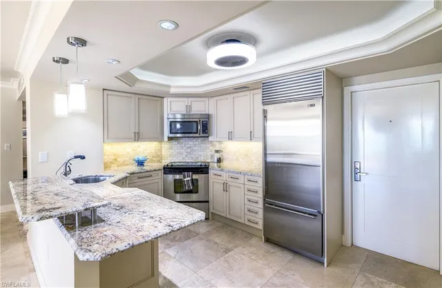 a kitchen with stainless steel appliances granite countertop a sink stove and refrigerator