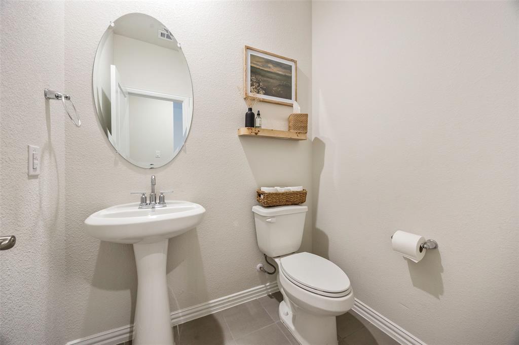 307 Quarry Street Melissa, TX 75454 - Photo 3 of 25 a bathroom with a toilet sink and mirror