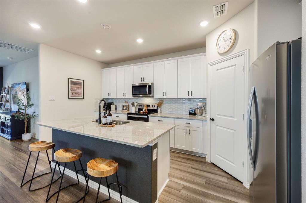 307 Quarry Street Melissa, TX 75454 - Photo 4 of 25 a kitchen with a refrigerator a stove a sink and chairs