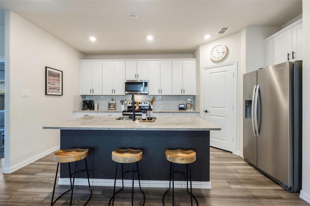 307 Quarry Street Melissa, TX 75454 - Photo 5 of 25 a kitchen with stainless steel appliances a dining table chairs and refrigerator