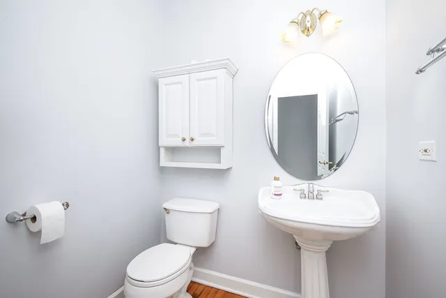 a bathroom with a toilet sink and mirror