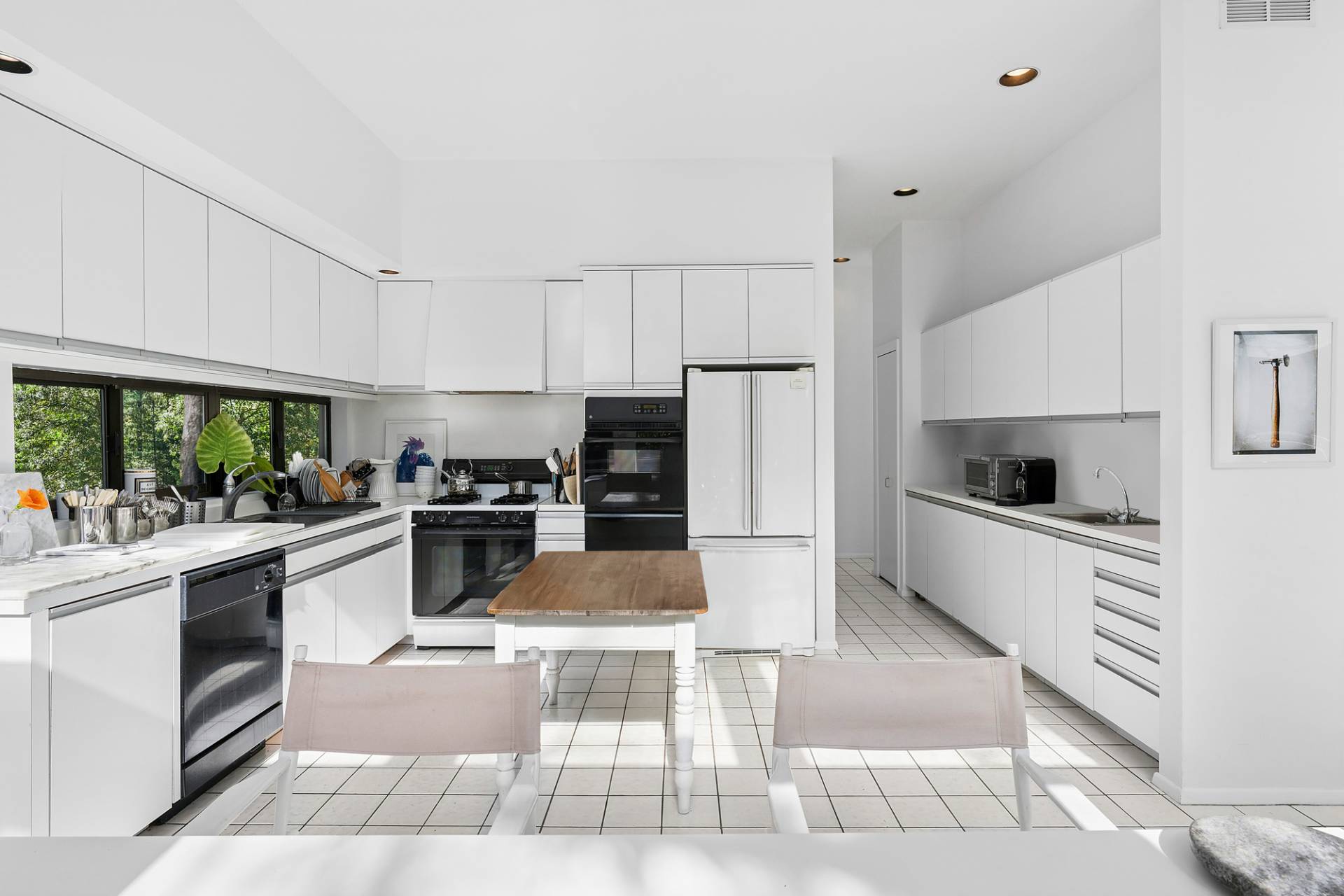 15 2 Holes Water Road East Hampton, NY 11937 - Photo 10 of 30 a kitchen with stainless steel appliances kitchen island granite countertop a refrigerator a stove a sink dishwasher and white cabinets with wooden floor