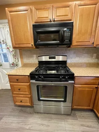 a stove top oven sitting inside of a kitchen
