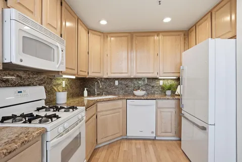 a kitchen with a white cabinets and white appliances