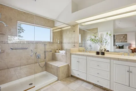a bathroom with a granite countertop sink mirror and bathtub