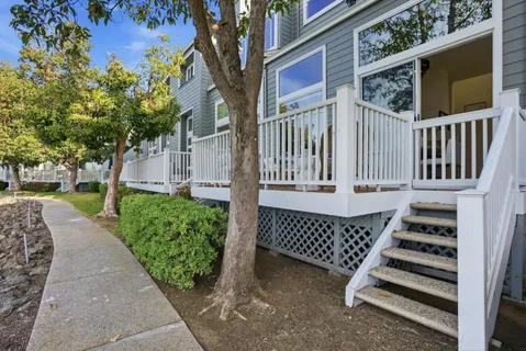 a view of a house with a small yard and wooden fence