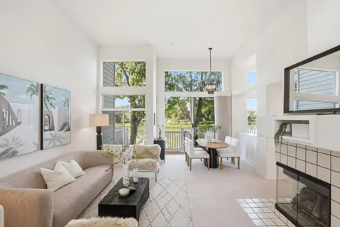 a living room with furniture large window and wooden floor