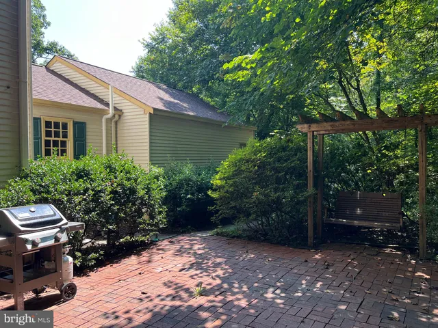 a spacious kitchen with stainless steel appliances granite countertop a refrigerator a sink dishwasher and wooden cabinets with wooden floor