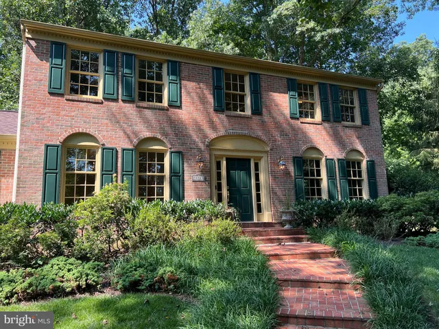 a front view of a house with yard and green space