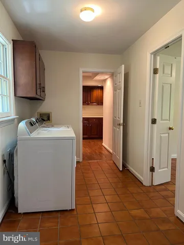 an empty room with wooden floor chandelier fan and windows