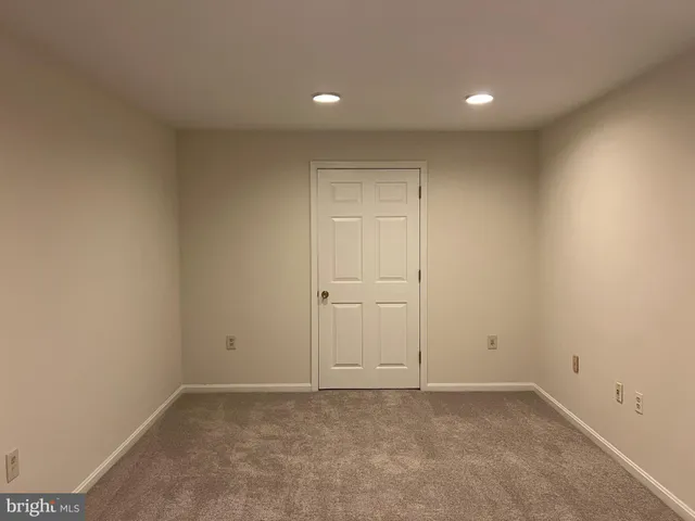 an empty room with wooden floor staircase and a ceiling fan